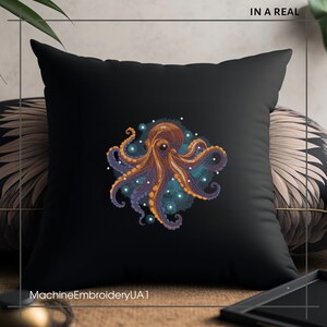 Puede incluir: Una almohada negra con un dise&ntilde;o de pulpo bordado de colores. El pulpo est&aacute; rodeado de un remolino azul y morado con puntos blancos. El texto "MachineEmbroideryUA1" est&aacute; en la parte inferior de la almohada.