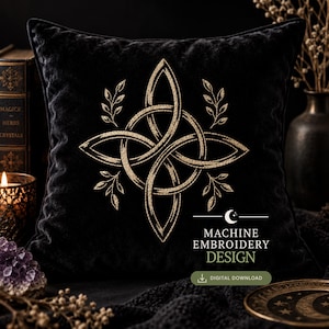 Può includere: Un cuscino quadrato in velluto nero con un motivo a nodo celtico ricamato in filo dorato al centro. Il ricamo include quattro rametti di foglie che circondano il nodo. Il testo sull'immagine recita MACHINE EMBROIDERY DESIGN DIGITAL DOWNLOAD.