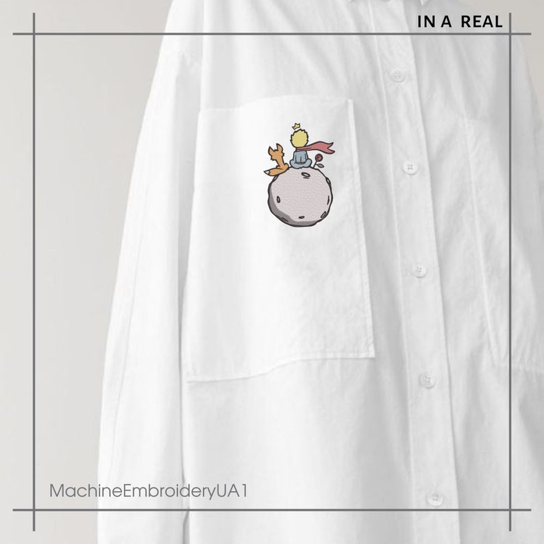 May include: White button-down shirt with a pocket featuring an embroidered image of The Little Prince sitting on an asteroid with a fox.