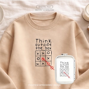 May include: A beige sweatshirt with the text "Think outside the box" and a tic-tac-toe game design. The design is in black, with a red line through the winning row. A smaller embroidered version is also shown.