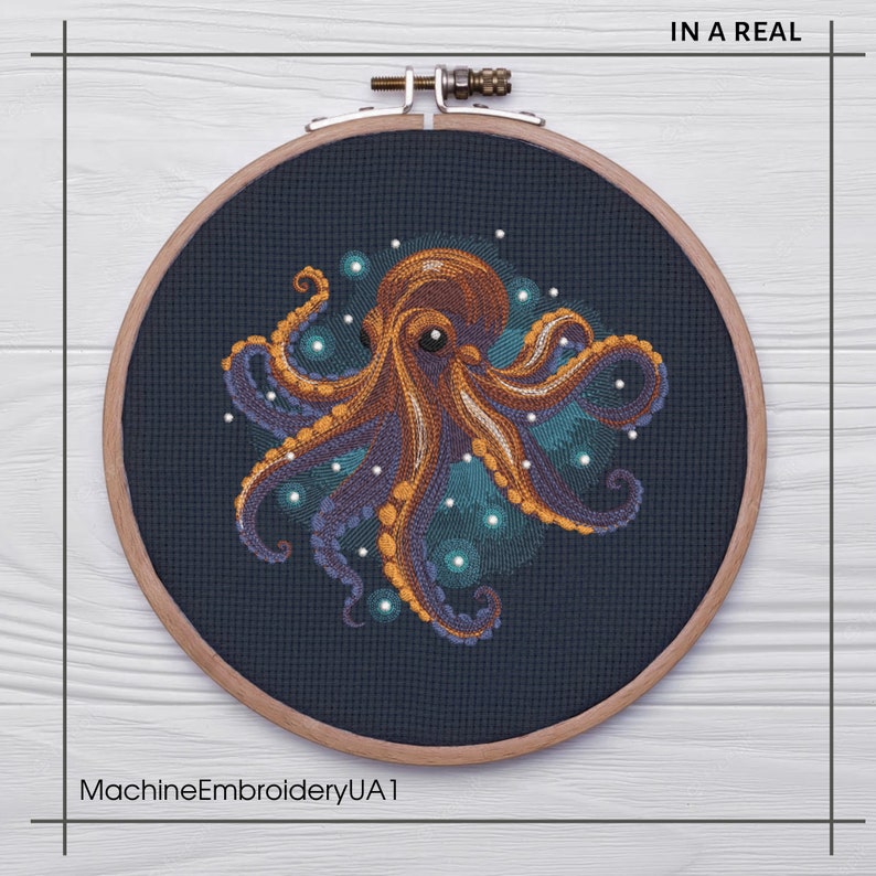 Puede incluir: Un primer plano de un aro de bordado circular con un fondo de tela azul oscuro. La tela presenta un dise&ntilde;o bordado detallado de un pulpo naranja con tent&aacute;culos morados rodeados de puntos blancos y azules. El texto "IN A REAL" es visible en la esquina superior derecha de la imagen.