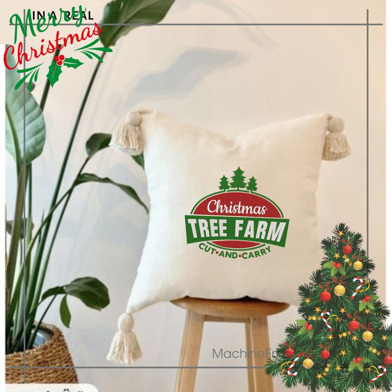 K&ouml;nnte beinhalten: Ein wei&szlig;es Kissen mit einem gr&uuml;nen und roten Weihnachtsbaum-Farm-Logo. Das Logo lautet "Christmas Tree Farm Cut and Carry". Das Kissen hat an den Ecken Quasten und steht auf einem Holzhocker. Im Hintergrund steht ein geschm&uuml;ckter Weihnachtsbaum.