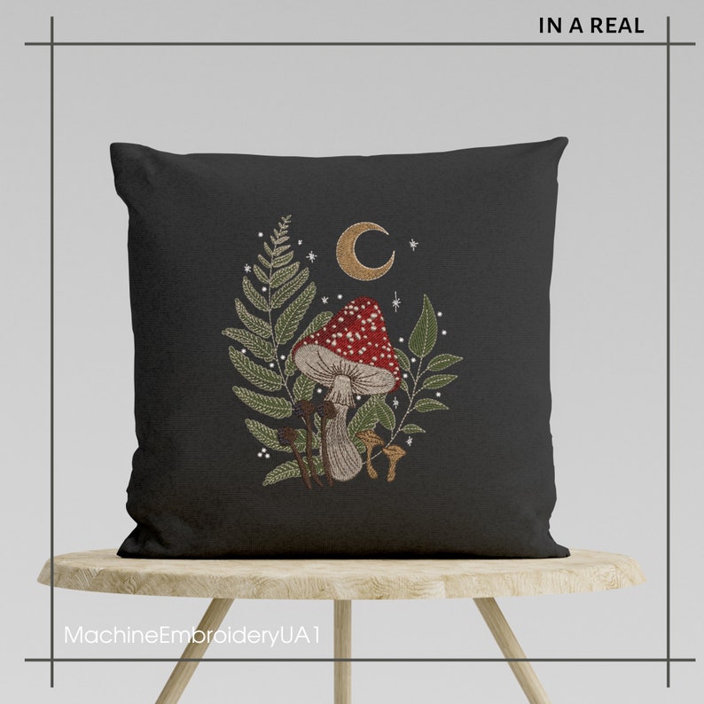 May include: A black pillow with a mushroom, fern, and crescent moon embroidered design. The embroidery is in shades of red, green, brown, and gold.