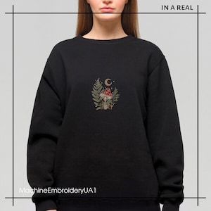 May include: Black sweatshirt with a machine embroidered design of a mushroom, leaves, and a crescent moon. The text "MachineEmbroideryUA1" is at the bottom of the image.