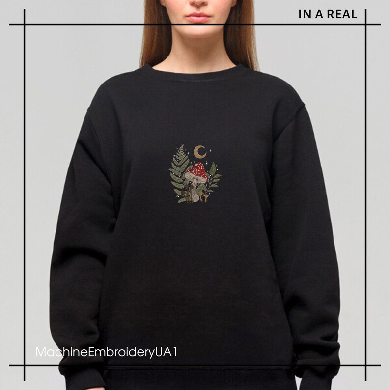 May include: Black sweatshirt with a machine embroidered design of a mushroom, leaves, and a crescent moon. The text "MachineEmbroideryUA1" is at the bottom of the image.