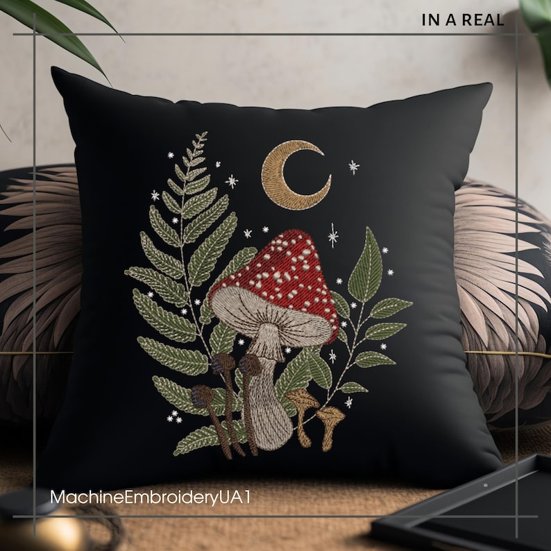 May include: Black pillow with embroidered design of a red and white mushroom, green leaves, and a crescent moon. The embroidery is done in white thread and the background is black.