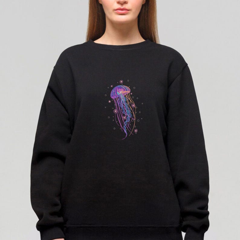 May include: A black sweatshirt with a colorful jellyfish graphic on the front. The jellyfish is surrounded by small, white circles that resemble bubbles.
