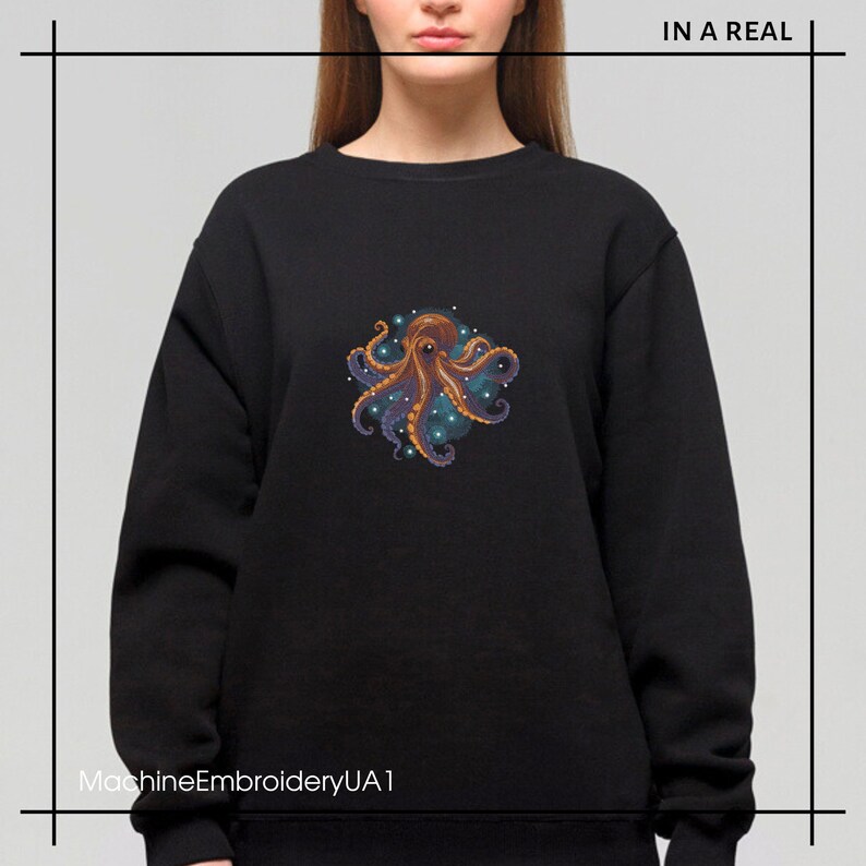 Puede incluir: Sudadera negra con un dise&ntilde;o de pulpo bordado de colores. El pulpo est&aacute; rodeado de un c&iacute;rculo de estrellas azules y blancas. El texto "IN A REAL" est&aacute; en la esquina superior derecha de la imagen. El texto "MachineEmbroideryUA1" est&aacute; en la esquina inferior izquierda de la imagen.