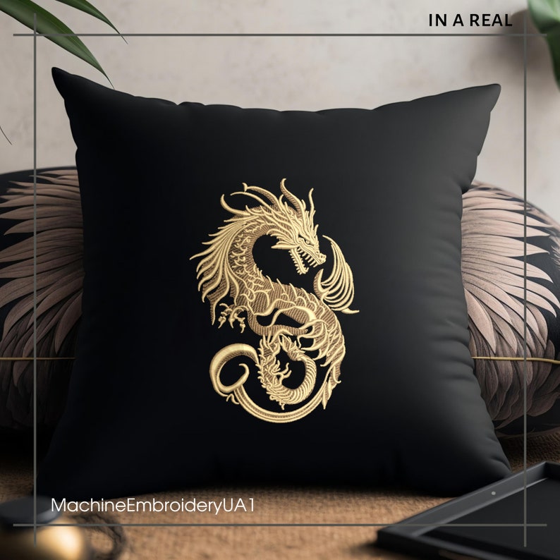 May include: Black throw pillow with gold embroidered dragon design. The pillow is on a brown surface with a gold tray and a plant in the background. The text "MachineEmbroideryUA1" is at the bottom of the pillow.