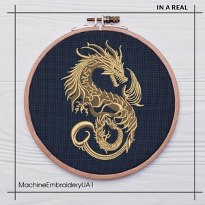 May include: A gold embroidered dragon design on a dark blue fabric in a wooden embroidery hoop. The text "IN A REAL" is in the upper right corner of the image. The text "MachineEmbroideryUA1" is in the lower left corner of the image.