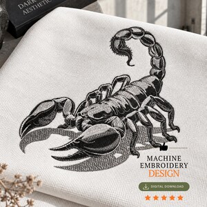 Könnte beinhalten: Ein Maschinenstickmuster mit einem detaillierten schwarzen Skorpion mit erhobenem Schwanz und großen Scheren, gestickt auf weißem, strukturiertem Stoff. Das Design enthält den Text MACHINE EMBROIDERY DESIGN und DIGITAL DOWNLOAD mit fünf Sternen.