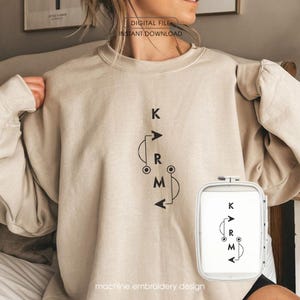 May include: Beige sweatshirt with a black graphic design that reads "KRM" with arrows and a circular design. The words "DIGITAL FILE INSTANT DOWNLOAD" are at the top. The words "machine embroidery design" are at the bottom.
