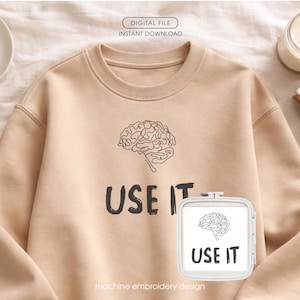 Może przedstawiać: Beżowa bluza z czarną grafiką m&oacute;zgu i napisem "USE IT". Widoczny jest r&oacute;wnież mały tamborek z tą samą grafiką m&oacute;zgu i tekstem. U g&oacute;ry widnieją słowa "DIGITAL FILE INSTANT DOWNLOAD".