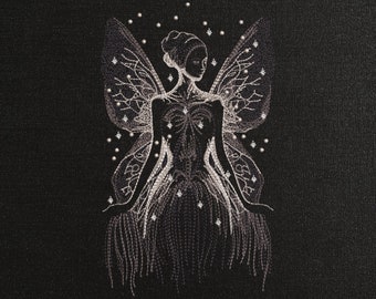 May include: A white embroidered design of a fairy with wings and a flowing dress on a black background. The fairy is surrounded by small white dots.