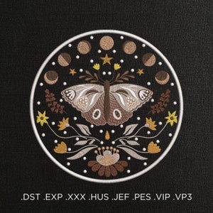 Può includere: Un disegno ricamato con una farfalla con ali marroni e bianche, circondata da fiori e lune crescenti in tonalità di marrone, giallo e bianco. Il disegno è su uno sfondo nero e racchiuso in un cerchio bianco.