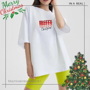 May include: A white short-sleeved t-shirt featuring the text merry merry merry Christmas in stacked red, pink, and black lettering. The shirt is paired with bright lime green shorts and is decorated with a Christmas tree graphic.