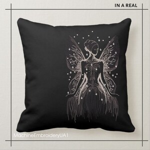 May include: Black throw pillow with a white embroidered design of a fairy with wings and a flowing dress. The fairy is surrounded by small white dots.