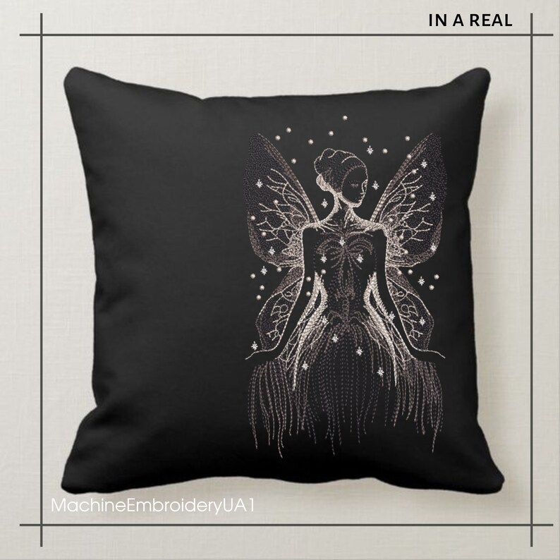 May include: Black throw pillow with a white embroidered design of a fairy with wings and a flowing dress. The fairy is surrounded by small white dots.