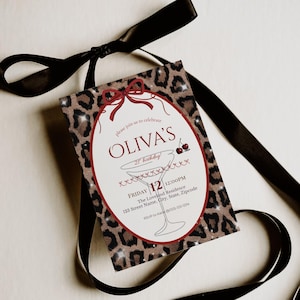May include: A party invitation with a leopard print background and a red oval frame. The invitation reads "OLIVA'S 21st birthday!" with event details. A black ribbon is tied around the invitation.