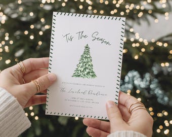 May include: A white invitation card with green stitched border and text "Tis The Season" and a watercolor Christmas tree illustration. The card also includes event details. The card is held by a person.