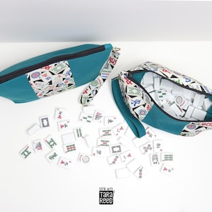 American Mahjong tile zipper pouch sewing pattern shown filled with 166 tiles, wrist strap, and teal and mahjong print fabric.