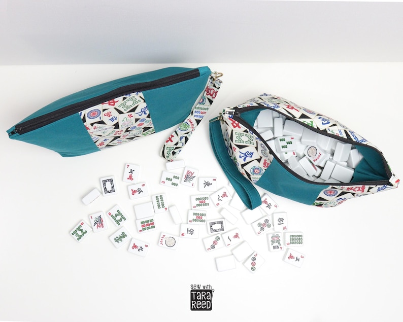 American Mahjong tile zipper pouch sewing pattern shown filled with 166 tiles, wrist strap, and teal and mahjong print fabric.