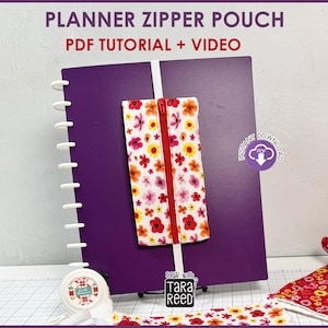 May include: A purple planner with a white spiral binding and a floral zipper pouch. The pouch has a red zipper and is decorated with pink, yellow, and orange flowers. The text "PLANNER ZIPPER POUCH PDF TUTORIAL + VIDEO" is at the top.