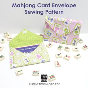 May include: Two fabric envelopes for Mahjong cards, one in light pink and one in light green, both featuring a Mahjong tile print. The envelopes are surrounded by scattered Mahjong tiles. Text reads Mahjong Card Envelope Sewing Pattern.