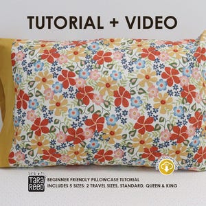 Op de afbeelding: Een kussensloop met een bloemenpatroon in rood, blauw, geel en roze. De kussensloop ligt op een wit oppervlak. De kussensloop heeft een gele rand. Tekst op de afbeelding luidt "TUTORIAL + VIDEO" en "BEGINNER FRIENDLY PILLOWCASE TUTORIAL".