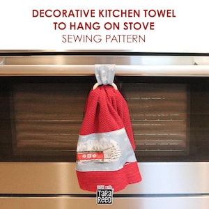 May include: A red textured kitchen towel with a light blue fabric band featuring a winter landscape and a wooden ring for hanging. The text DECORATIVE KITCHEN TOWEL TO HANG ON STOVE SEWING PATTERN and SEW WITH TARA REED are visible.