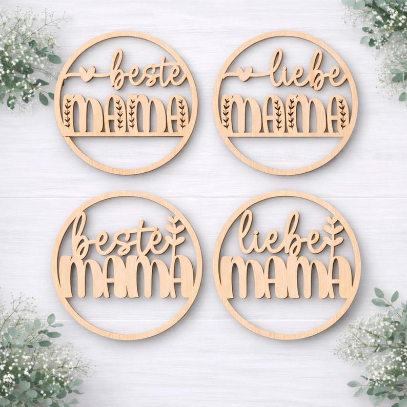 K&ouml;nnte beinhalten: Vier runde Holzdekorationen mit den Worten "beste MAMA" und "liebe MAMA" in einer Schriftart ausgeschnitten. Jeder Kreis hat einen dekorativen Rand und ein Herz- oder Blattdesign. Das Holz ist hell und nat&uuml;rlich.