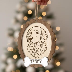 May include: Wooden dog ornament with a scalloped edge and a light brown frame. The ornament features a detailed line drawing of a dog's face within an oval. A bone-shaped tag below reads "TEDDY". A natural twine loop is attached for hanging.