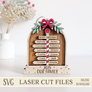 May include: Wooden Christmas ornament with a signpost design. The ornament features the text "Merry Christmas" and "Our Family 2025". Names are listed on directional signs. The ornament is decorated with a red bow and green leaves. The bottom of the ornament reads "SVG LASER CUT FILES DIGITAL DOWNLOAD".