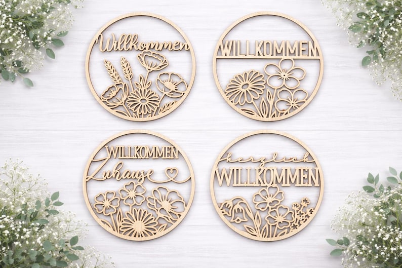 Pu&ograve; includere: Quattro cartelli circolari in legno tagliati al laser con disegni floreali e la parola "Willkommen" in vari stili. I cartelli sono marrone chiaro e presentano intricati dettagli ritagliati di fiori e fogliame.
