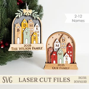 May include: Wooden Christmas ornaments with a cityscape design, personalized with family names and the year 2025. The laser-cut ornaments feature the text "THE WILSON FAMILY" and "OUR FAMILY". The houses are in various colors, suitable for festive decor.