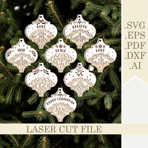 May include: Set of eight laser cut wooden Christmas ornaments with intricate designs. Each ornament features a different holiday word, including "Noel", "Believe", "Joy", "Peace", "Love", and "Merry Christmas".