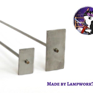 Puede incluir: Dos herramientas de lampwork metálicas con placas rectangulares y varillas largas. Las herramientas son de acero inoxidable y están sobre un fondo blanco. El texto "MADE BY LAMPWORKTOOL" está en la parte inferior derecha.