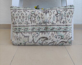 Puede incluir: Una almohada decorativa con fondo blanco y un patrón floral tradicional en tonos marrones, verdes y azules.