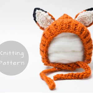 Op de afbeelding: Breipatroon voor een vossenmuts. De muts is oranje met zwarte en witte vossenoren. De muts heeft een strik onder de kin.
