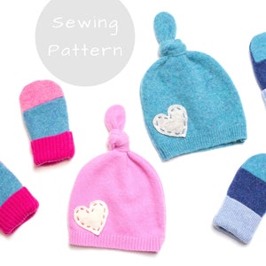 Może przedstawiać: Wzór szycia na zestaw czapek i rękawiczek dla niemowląt. Czapki są różowe i niebieskie z białą aplikacją w kształcie serca. Rękawiczki są różowe i niebieskie z białym paskiem.