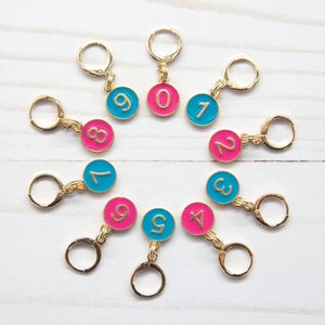 Puede incluir: Diez marcadores de punto de oro con cuentas redondas de color azul turquesa y rosa alternadas. Cada cuenta tiene un número dorado del 0 al 9.