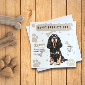 May include: A Father's Day card featuring a black and tan Cocker Spaniel dog with the text "Happy Father's Day" and "Love Albie". The card has a paw print background.