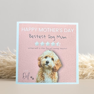 May include: A square greeting card with a light pink background and a light blue border. The card reads "HAPPY MOTHER'S DAY Bestest Dog Mum" with a photo of a dog. The text "missed half a star for not enough treatos" is also included.