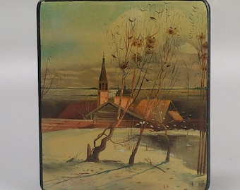May include: A hand-painted wooden box with a winter scene depicting a church with a tall steeple, a small house, and trees in the foreground. The scene is painted in muted tones of brown, green, and white.