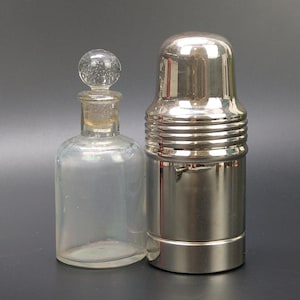 Vintage kleine Medizinglasflasche im Metallgehäuse