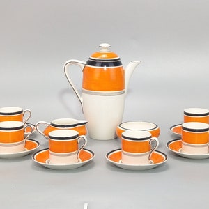 Könnte beinhalten: Ein vintage Kaffeekanne-Set in Orange und Schwarz mit einer Teekanne, einer Milchkännchen, einer Zuckerdose und sechs Tassen und Untertassen.