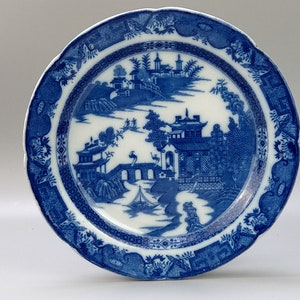 May include: A blue and white porcelain plate with a Chinese landscape design. The plate has a scalloped edge and a decorative border.