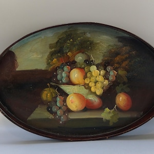 May include: Oval wooden tray with a still life painting of fruit. The painting features peaches, grapes, and a small gourd in a bowl. The tray has a dark brown border and a painted background of trees and a wall.