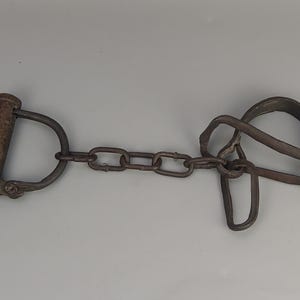 Antique wrought iron semicircular manacle with short chain and key, 18th century
