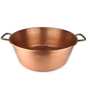 Puede incluir: Una olla grande de cobre con dos asas de latón. La olla está vacía y tiene una superficie brillante y reflectante.